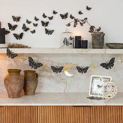 Decorative mantel with butterflies, candles, and vases against a light wall.